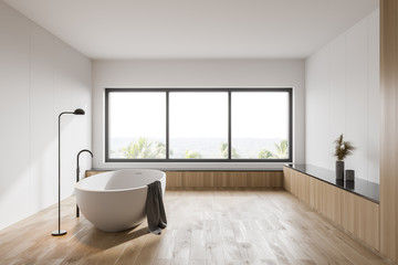 White and wooden bathroom with tub and window