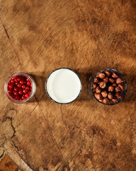 Yogurt with nuts on a wooden light background. View from above. Natural yogurt.