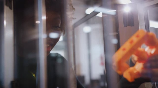 Female college student studying engineering using 3D printing machine - shot in slow motion