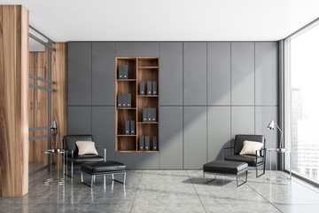 Gray office lounge with armchairs and bookcase