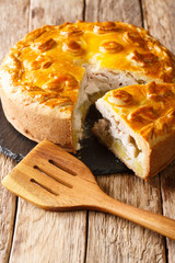 Kurnik sliced pie with chicken, potatoes and onions close up on a slate board. vertical © FomaA