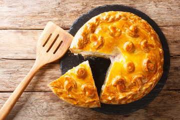 Kurnik sliced pie with chicken, potatoes and onions close up on a slate board. horizontal top view © FomaA