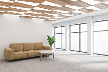 White office waiting room corner with beige sofa