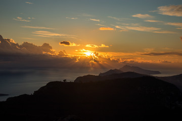 the promontory of the Sorrento peninsula and the island of capri in the background at sunset,...