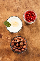 Yogurt with nuts on a wooden light background. View from above. Natural yogurt.