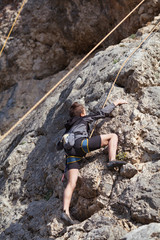 A teenager on a rock is engaged in rock climbing, children's sports in nature, outdoor activities for children