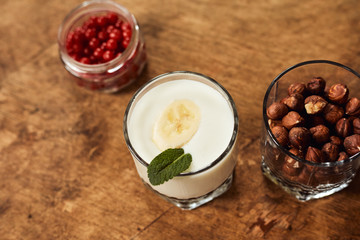 Yogurt with nuts on a wooden light background. View from above. Natural yogurt.