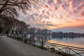 Obraz premium sunset in the city. View to the lake Pamvotis and Ioannina city at sunset.Greece