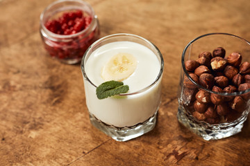 Yogurt with nuts on a wooden light background. Natural yogurt.