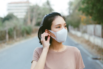 The image face of a young Asian female wearing a mask to prevent germs, toxic fumes, and dust. Prevention of bacterial infection Corona virus or Covid 19 in the blur background