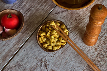Bowl with ravioli, chopsticks and pepper mill