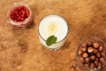 Yogurt with nuts on a wooden light background. View from above. Natural yogurt.