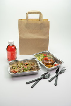 Delivery of delicious healthy food in foil boxes. Concept of food delivery in quarantine, self-isolation.