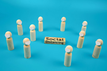 Covid-19 protection concepts. A wooden doll with a face mask stand spaced for social distance.