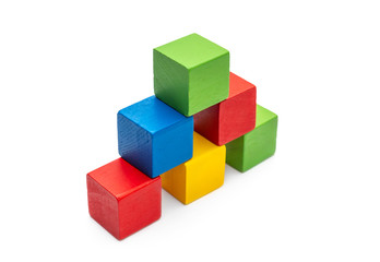 Pyramid from colorful wooden toy bricks on white.