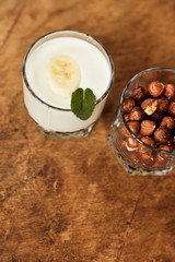 Yogurt with nuts on a wooden light background. Natural yogurt.
