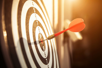Bullseye(bull's-eye) or dart board has dart arrow hitting the center of a shooting target for...