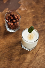 Yogurt with nuts on a wooden light background. Natural yogurt. View from above. Summer food.