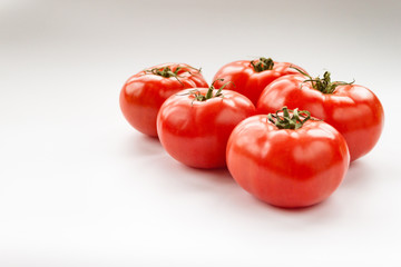 Tomato few vegetables on white background close up vertical. Selective focus. Copy space