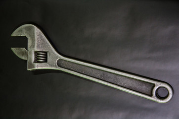 big adjustable wrench on a black background. tool for the mechanic. close-up