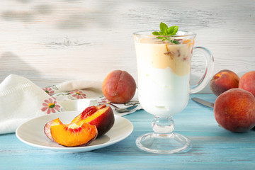 Peach yogurt with mint and a spoonful of fresh fruit on the table. Healthy breakfast. Vegetarianism