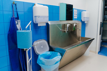 Hand wash room in the hospital. Sterile steel washbasin in modern surgery room