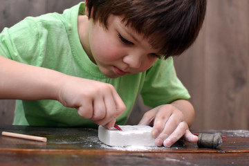 Children having fun with archaeology excavation kit. Boy plays an archaeologist excavated, training...