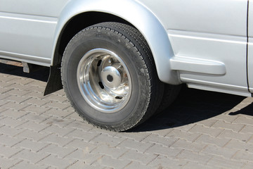 Wheel of a gray truck while stopping on a tile