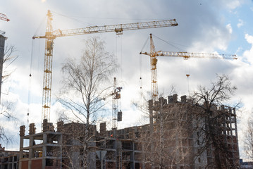 Tower building cranes build new multi-storey houses from monolithic frame and monolithic brick structure