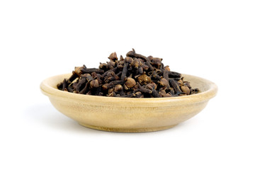 Closeup cloves on wooden bowl – isolated on white background