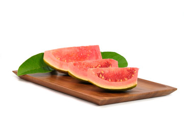 Fresh Psidium guajava / common guava / lemon guava sliced and raw fruit on a wooden plate isolated on a white background