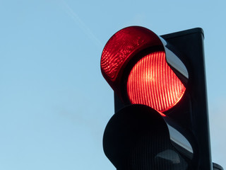 Red traffic light with blue sky background