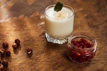 Yogurt with nuts on a wooden background. Side view. Summer food.