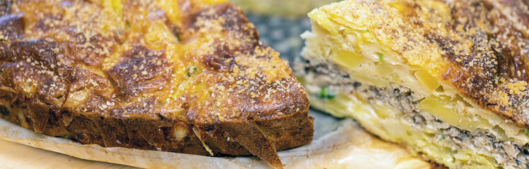 Homemade yeast-free cake on kefir with a filling of canned fish and potatoes, close-up.