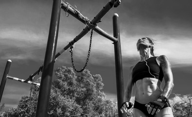 Woman getting ready to do exercises on the outdoor horizontal bar