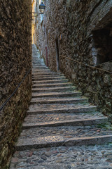 A narrow street in downtown of the medieval city of Girona, Spain.