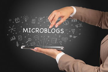 Obraz premium Close-up of a touchscreen with MICROBLOGS inscription, social media concept