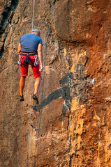 man climber on a rock with rope