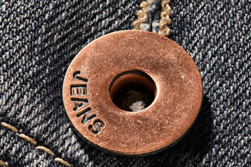 a brass button with jeans natural clean background macro photo, dark blue pattern texture, design...