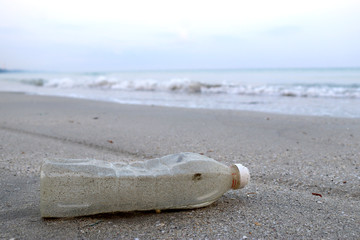 Bottle plastic on the beach ground show long life garbage concept