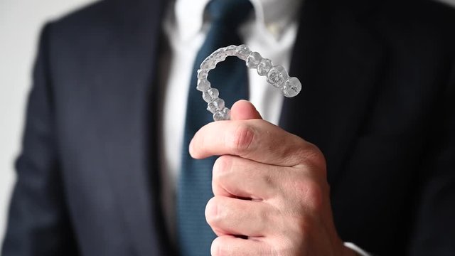 Professional showing dental clear aligners.