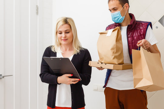 Delivery Man Holding Paper Bag With Food On White Background, Food Delivery Man In Protective Mask