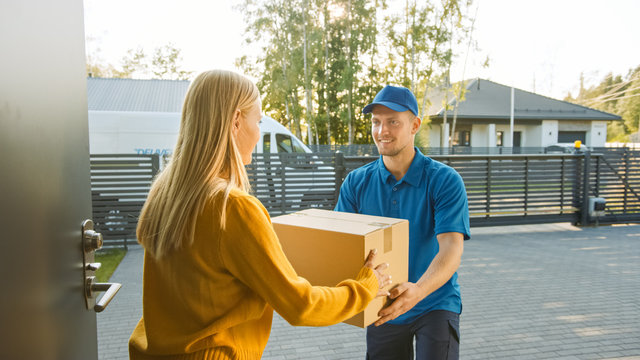 Beautiful Young Woman Meets Delivery Man who Gives Her Cardboard Box Package. Courier Delivering Parcel in the Cute Suburban Neighborhood