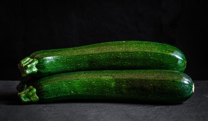 two zucchini on black background green food fresh vegetable