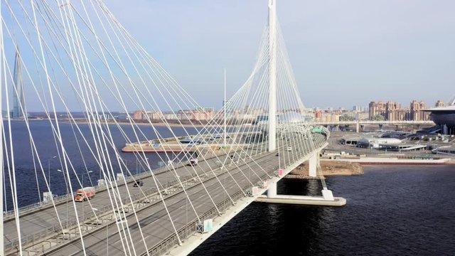 traffic on cable bridge in St. Petersburg, aerial view. Sunny day. Lakhta center tower skycraper in a background