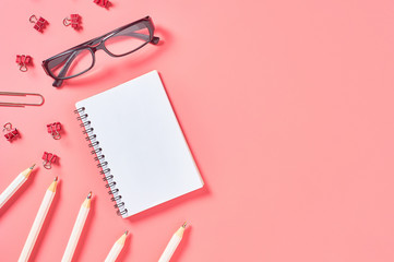 Workplace with stationery accessories on pink countertop. Business or back to school concept. Secretaries workspace. Top view. Flat lay. Copy space