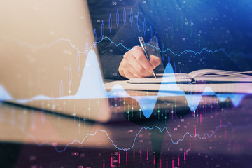 Double exposure of businessman with laptop and stock market forex chart.