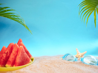 Fototapeta na wymiar Watermelon and swimming goggles on beach.