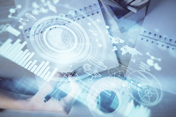 International business hologram over hands taking notes background. Concept of success. Multi exposure