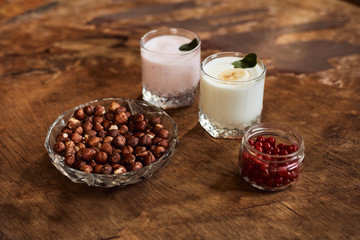Yogurt with nuts on a wooden background. Side view. Summer food.